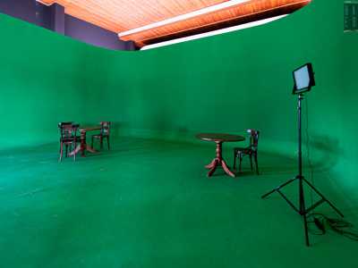 Saliamo ora al piano superiore, dove entriamo in una stanza che contiene un locale semicircolare di colore verde: si chiama green screen e serve per aggiungere in postproduzione ambienti o persone 